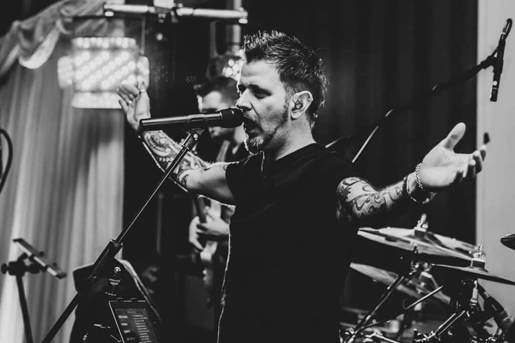 A black and white photo of Tony Ward performing passionately on stage